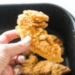 a piece of chicken tender in hand