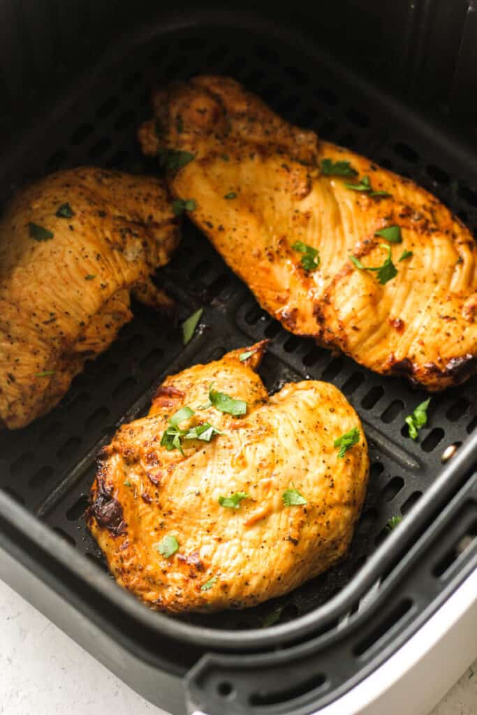 chopped cilantro on top of cooked chicken breasts