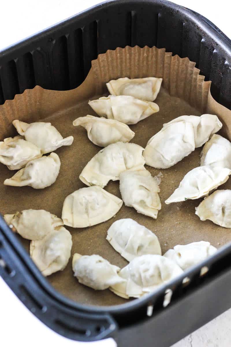frozen raw dumplings in the air fryer basket before cooking