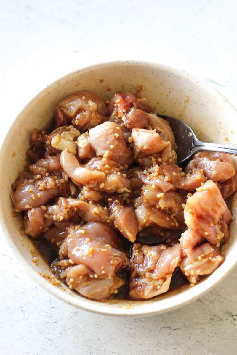 marinating chopped chicken thighs in the bowl