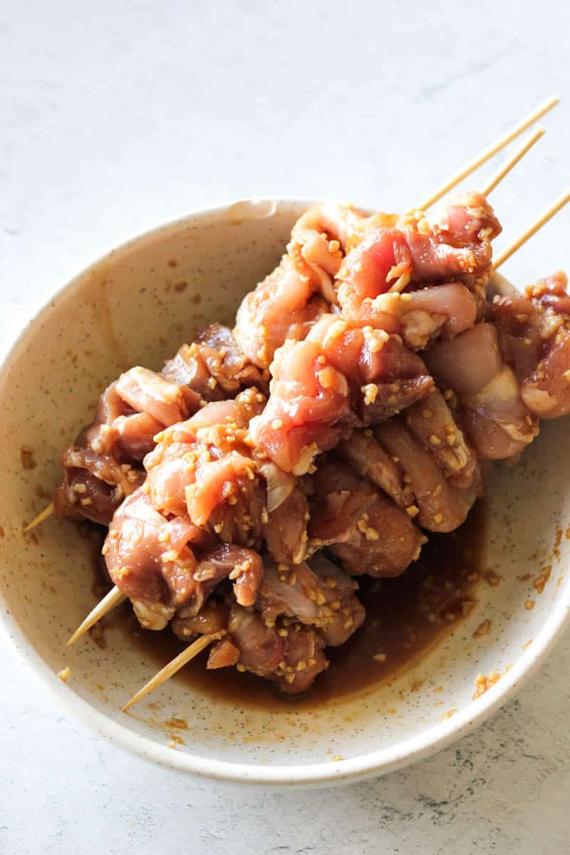 marinated chicken on sticks in the bowl