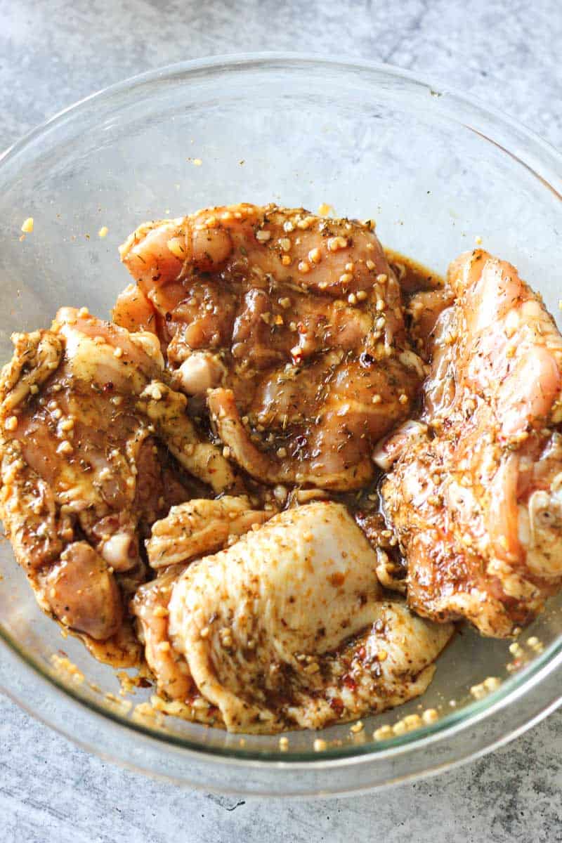 marinating chicken thighs in a glass bowl