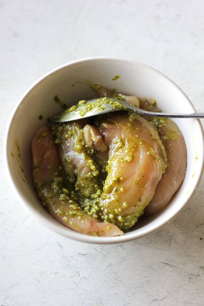 raw chicken in pesto sauce in a bowl