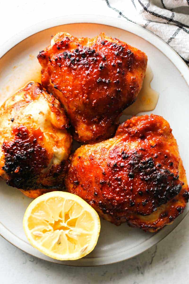 air fried gochujang chicken thighs with lemon on the plate