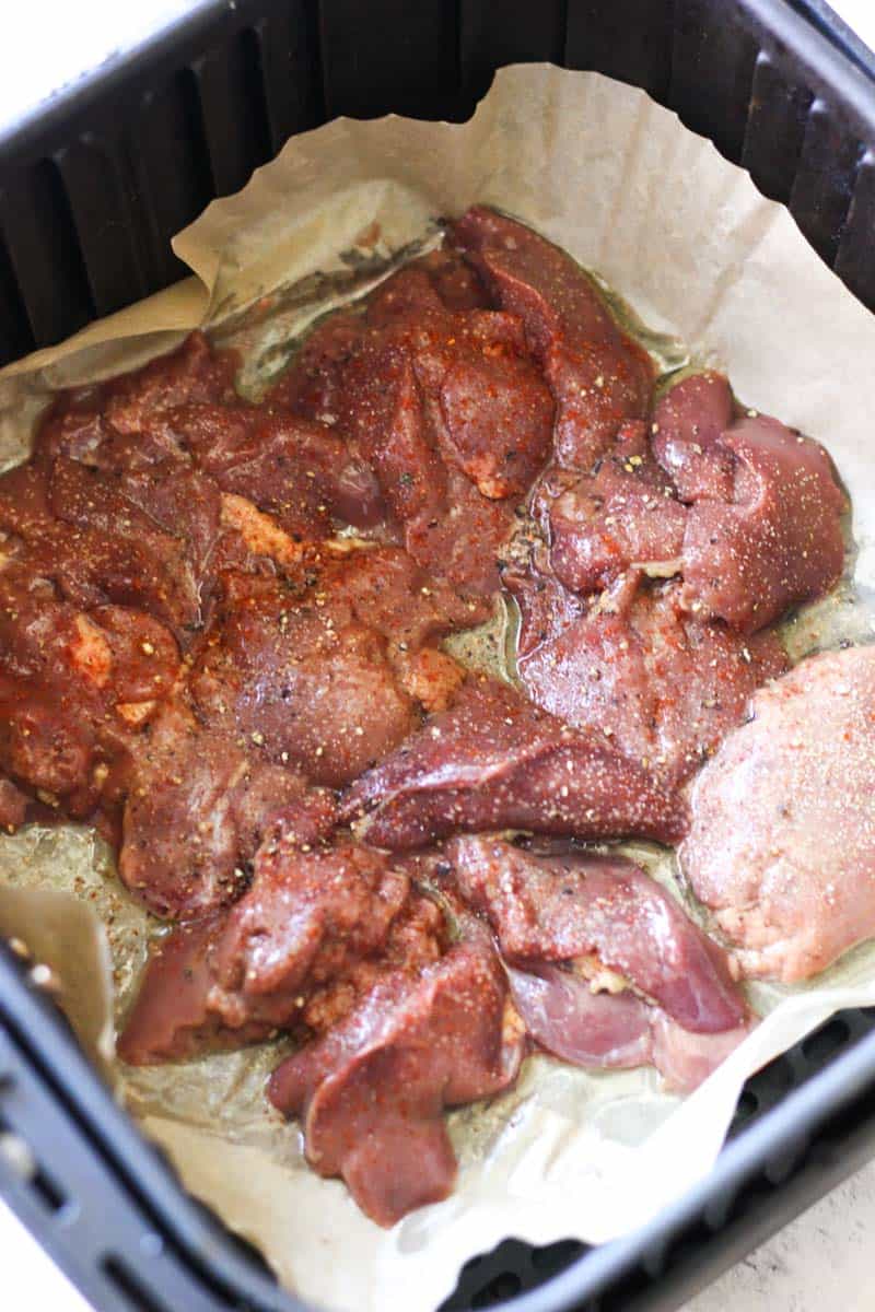 seasoned raw chicken liver in the air fryer about to be cooked