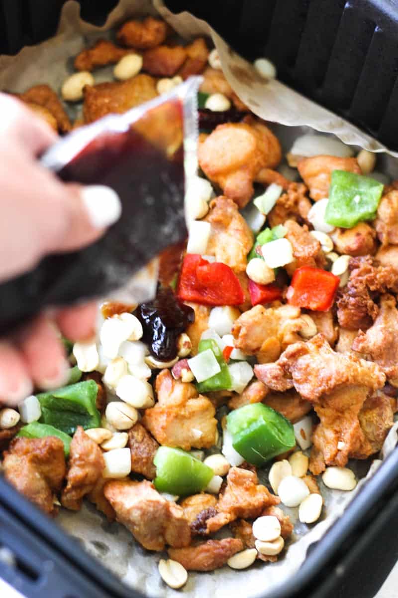 adding kung pao sauce to the chicken and vegetables