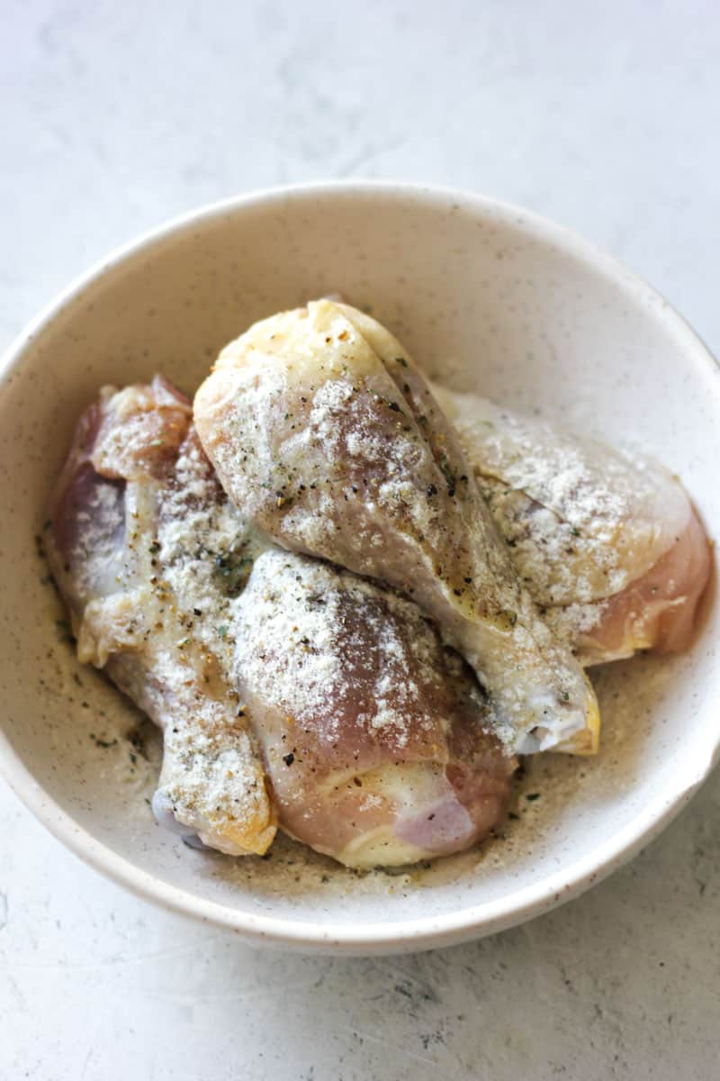 marinating chicken drumsticks in white colored spices