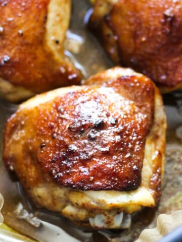 chicken thighs cooked in the air fryer with crispy brown skin covered in maple sauce