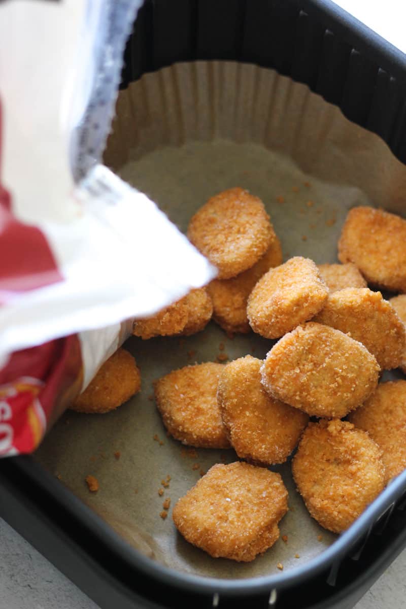 pouring nuggets in to the air fryer basket