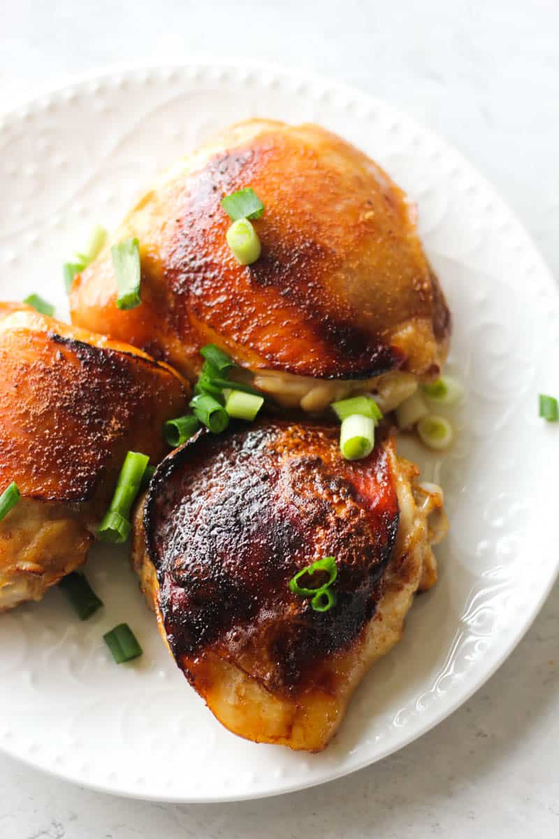 three chicken thighs with brown skin on the plate